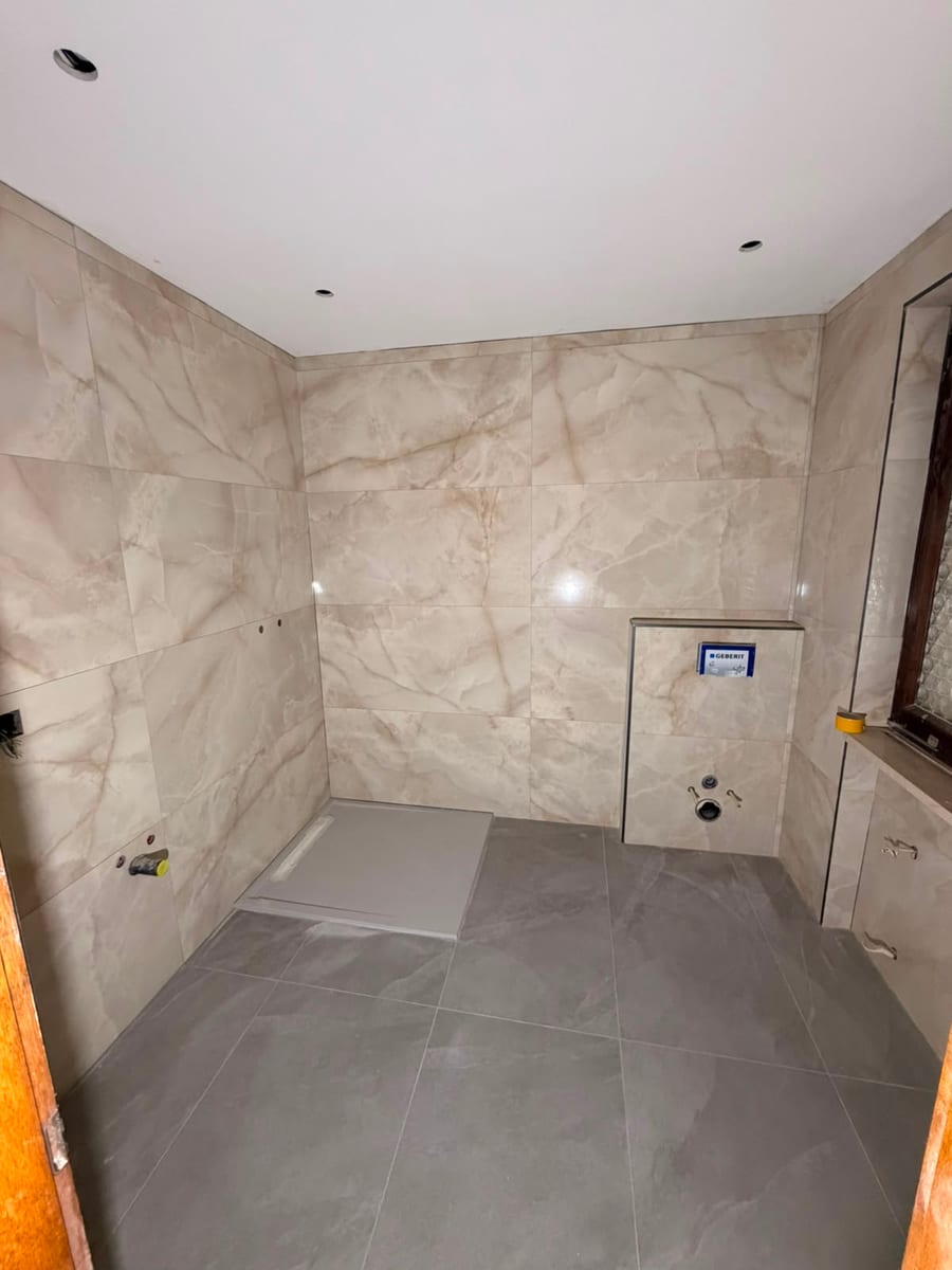 Dopo — rifacimento di un bagno con rivestimento in gres effetto marmo e doccia a filo pavimento in Ticino